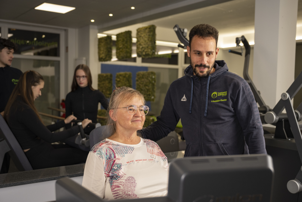 Training mit Milon für jedes Alter, Senioren bekommt Einweisung von Trainer am Gerät